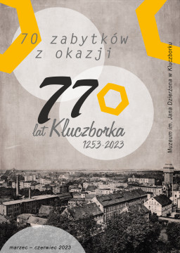 Plakat wystawy "70 zabytków z okazji 770 lat Kluczborka", ekspozycja czynna: marzec-czerwiec 2023. W dolnej części plakatu pocztówka z panoramą miasta.